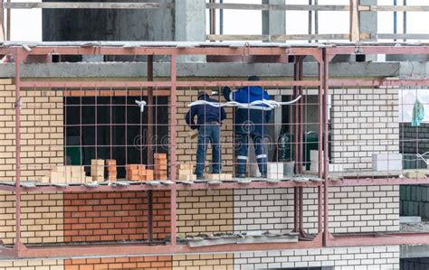 Workers Lay Brick Walls At The Construction Site Of A Multi Storey