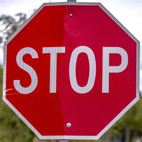 Red Stop Sign Against Trees And Sky On A Sunny Day Stock Image