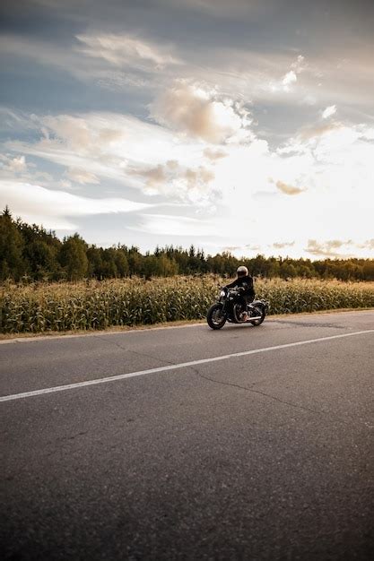 Premium Photo Motorcyclist Rides On The Highway During Sunset