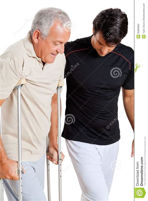 Trainer Helping Senior Man With Crutches Stock Photo Image Of Retired