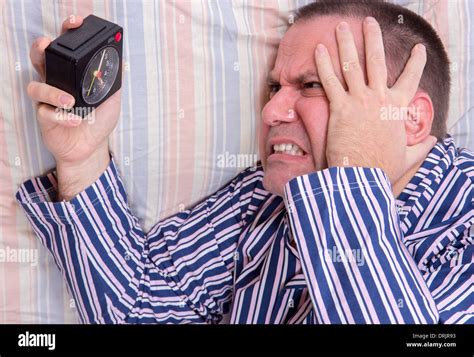 Man In Bed Watching Alarm Clock Stock Photo Alamy