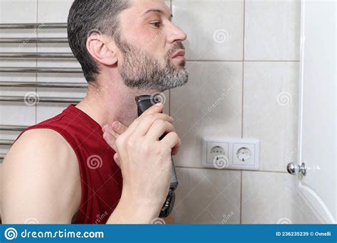 A Young Man Shaves With An Electric Shaver In The Bathroom Stock Image Image Of Beautiful