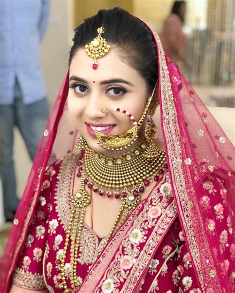 A Woman In A Red And Gold Bridal Outfit With Jewelry On Her Head