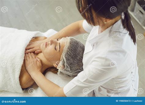 Masseur Making Professional Manual Relaxing Massage For Womans Face And Upper Shoulder Girdle