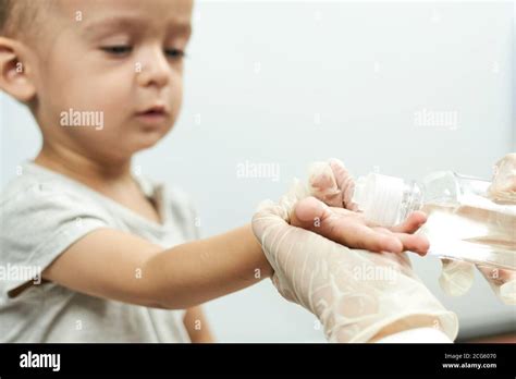 Doctor Putting Hand Sanitizer To Baby Hands Teaching A Baby Boy Hand