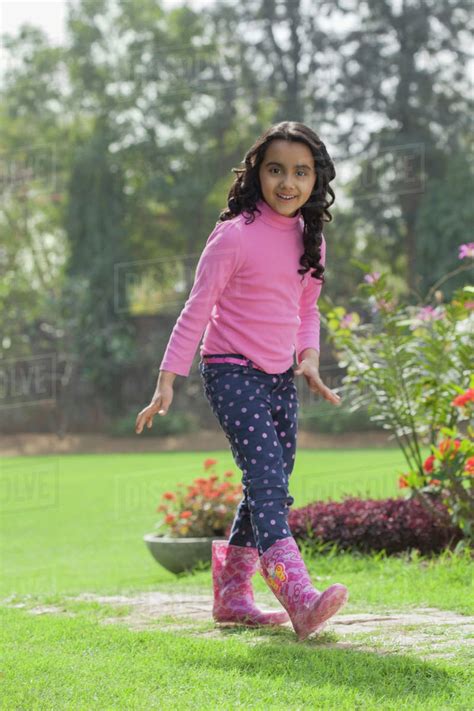 Girls in deep mud 4. Young girl wearing rubber boots walking in garden - Stock ...