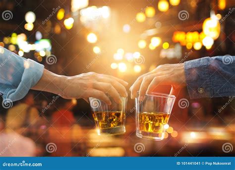 cheers clinking of friends with bourbon whisky drink in party stock image