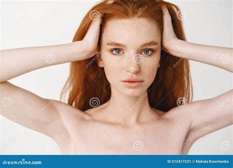 Close Up Of Relaxed Young Redhead Woman With Pale Skin And Freckles Massaging Natural Red Hair