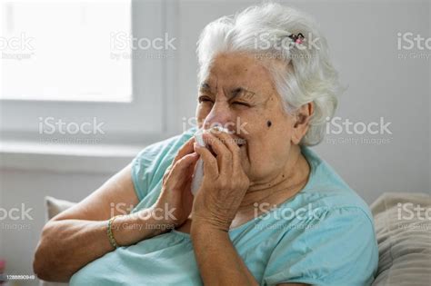 아픈 노인 여자 와 종이 닦아 불고 그의 코 에 집에서 재채기에 대한 스톡 사진 및 기타 이미지 재채기 노인 여자 노인 Istock