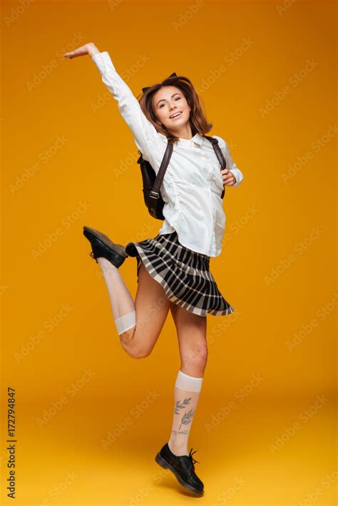 Full Length Portrait Of A Happy Teenage Schoolgirl In Uniform Stock