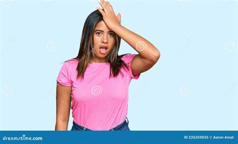Young Latin Girl Wearing Casual Clothes Surprised With Hand On Head For