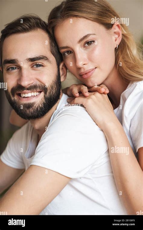 Beautiful Happy Young Couple In Love Embracing At Home Looking At