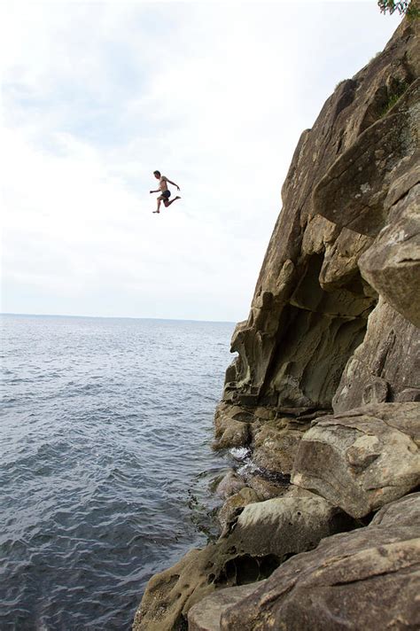 Man Jumping Off A Cliff Into Water Photograph By Adam Clark Fine Art
