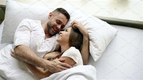 Young Beautiful And Loving Couple Talk And Hug Into Bed While Waking Up