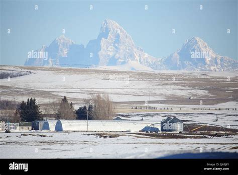 Farmland And Farm Buildings In Front Of The Teton Mountain Range In