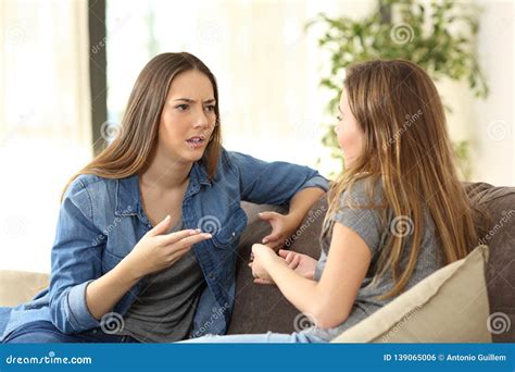 Serious Women Talking On A Couch At Home Stock Photo Image Of Annoyed