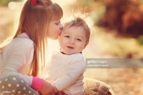 Sister Kissing Her Brother In Winter Sunshine Photo Getty Images