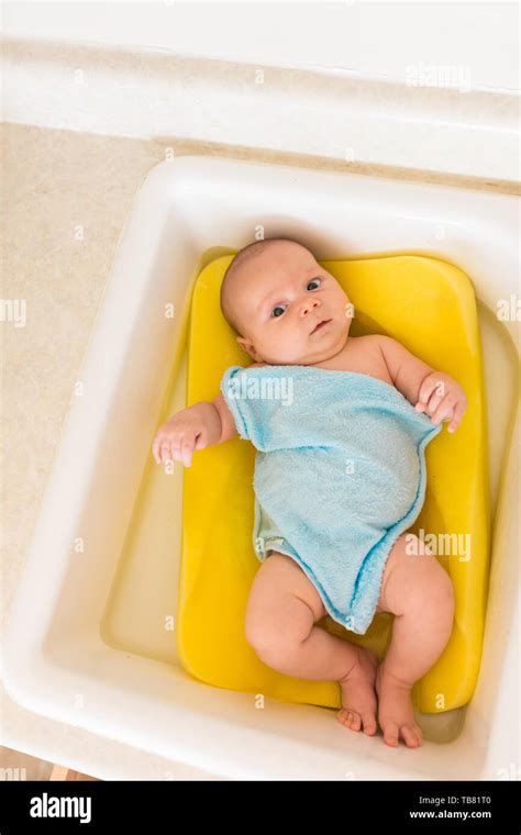 Cute Innocent Newborn Baby Getting A Bath In The Kitchen Sink Stock