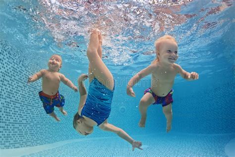 Дети плавают и ныряют под водой с потехой в бассейне Стоковое Фото