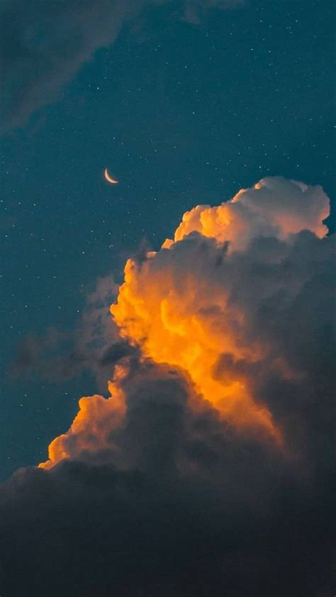 The Moon Is Shining Brightly In The Night Sky Above Clouds And Stars