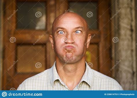 Portrait Of An Emotional Bald Guy With Blue Eyes Dressed In Light