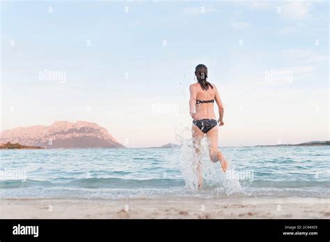 Back View Of Woman In Bikini Running Into The Sea Sardinia Italy