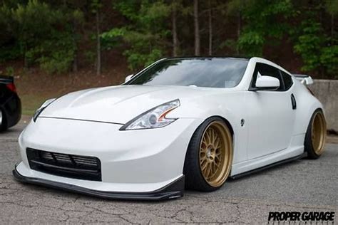 a white sports car parked in front of some trees