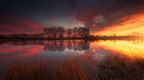 Lake Between Green Grass And River During Sunset Under Red