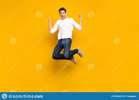 full length body size photo man gesturing like winner jumping up isolated vivid yellow color