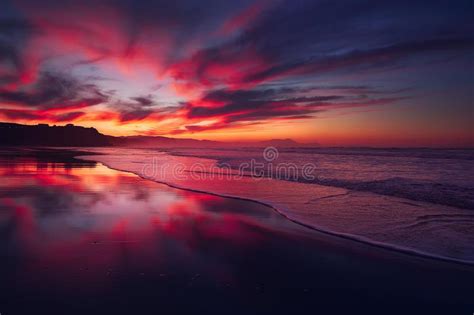 Puesta De Sol Rojo En La Playa Con Una Ola En La Orilla Imagen De
