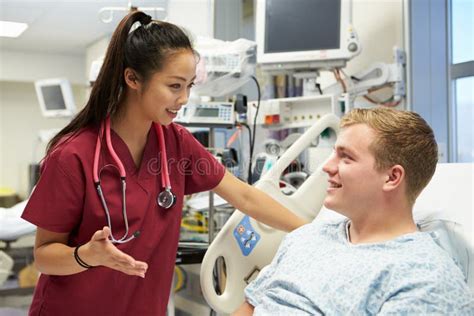 Young Male Patient Talking To Female Nurse In Emergency Room Stock