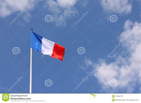 French Flag Tricolore Waving From A Flag Pole With Blue Sky Background