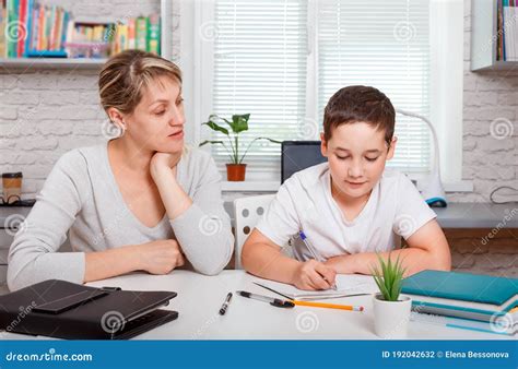 A Schoolboy Boy Studies At Home And Does School Homework Online Stock