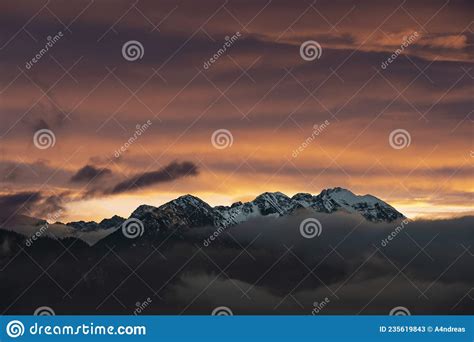 Dark Afterglow At Sunset Over The Fog Shrouded Austrian Alps Mountains