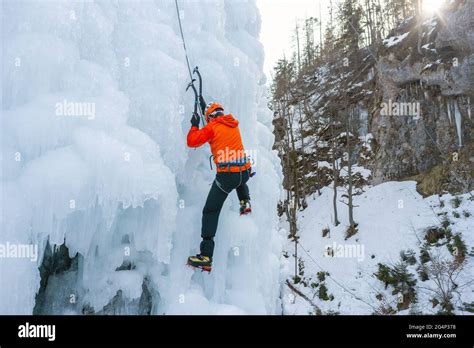 Athlete Climb Frozen Waterfall Swinging The Axe Pick Into The Ice And