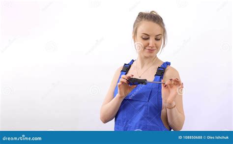 Seductive Beautiful Woman In Blue Overalls With Screwdriver At White