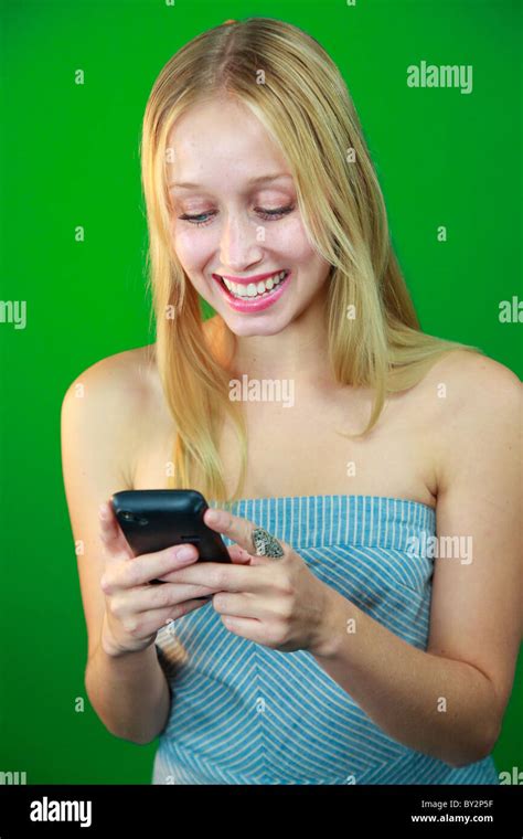 Blond Caucasian Young Woman In Front Of Green Screen Talking Texting