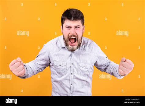 Aggressive Man Screaming Clenched Fists On Orange Background Stock