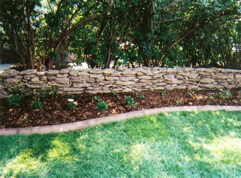Garden wall natural stone and a bamboo fence. Garden Design- Setting the Standard of Your Home - Abode