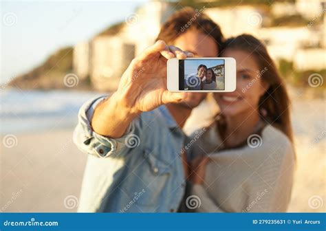 Love At The Beach An Affectionate Young Couple Taking A Selfie At The