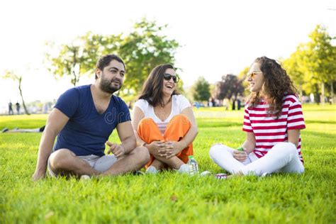 Three Friends Sitting On The Grass In The Park Stock Image Image Of