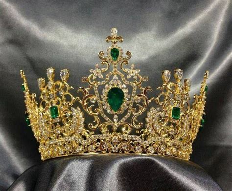 A Gold And Green Tiara Sitting On Top Of A Black Cloth