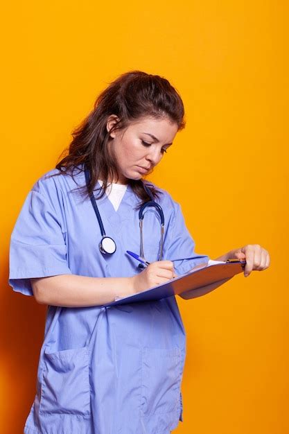 Free Photo Woman Nurse With Uniform Writing On Clipboard Papers