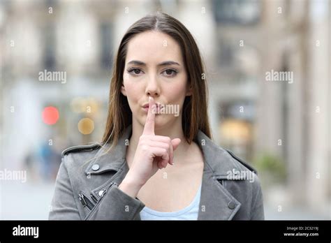Front View Portrait Of Serious Woman Asking For Silence With Finger On