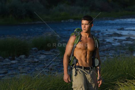 Good Looking Shirtless Young Man Hiking In The Rio Grande In New Mexico