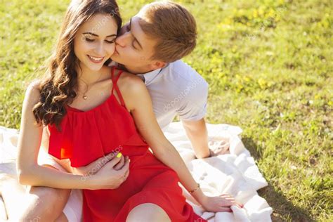 Beautiful Brunette Couple In Love Kissing On A Date In The Park Stock