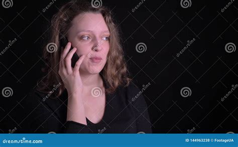 Portrait Of Young Curly Haired Girl Talking Joyfully On Smartphone On