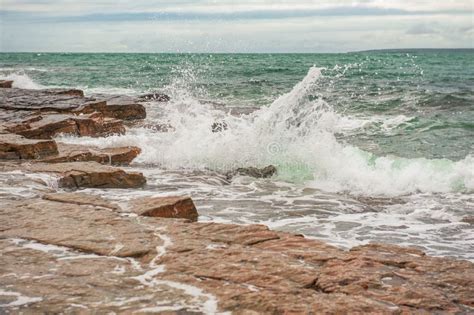 Dramatic Scene With Sea Waves Rocky Seashore And Clouds Stock Image