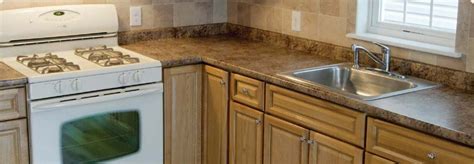 Gourmet kitchen features white shaker cabinets with marble countertops, stone subway tile backsplash, double door stainless steel refrigerator. In-Stock Cabinets - Building Materials & Supplies