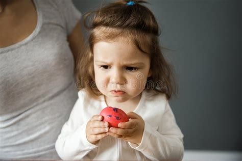 Upset Young Girl Is Holding A Red Easter Egg With Her Hands Bad Taste